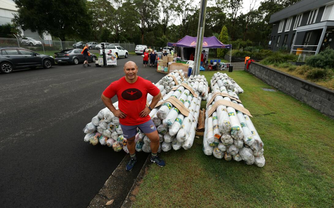 DONATIONS: Sione Finefeuiaki with rolls of fabric given by Rutherford firm Wax Converters Textiles Australia.