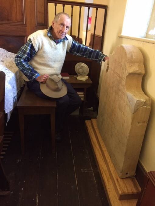 PRESERVED: Historian Jonathan King inspects the memorial stone in its new position inside the church.
