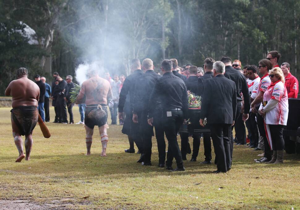 RESPECT: A didgeridoo performance and traditional smoking ceremony and a guard of honour formed by Karuah Roos rugby league club members pay respect to Ben Langdon as his coffin is carried into the funeral service. Pictures: Simone De Peak 