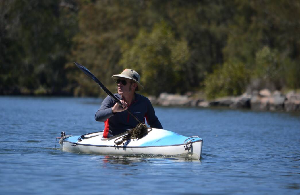 Photographer Nick Raschke paddles his kayak along Cockle Creek, in search of his next subject. Picture: Scott Bevan
