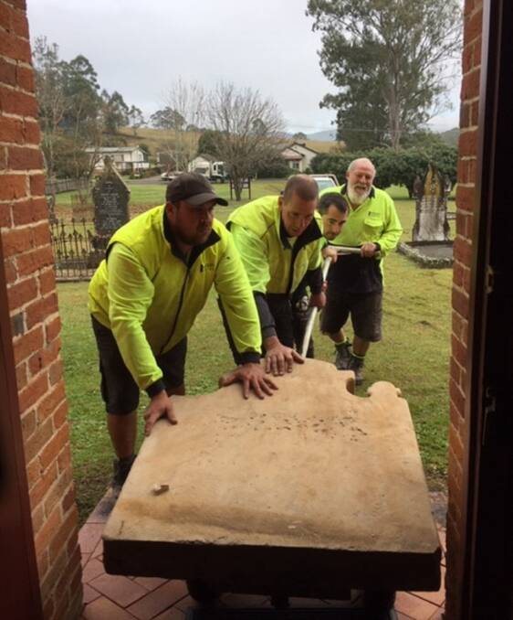 CAREFUL: Stonemasons, led by Arthur Whyte-Butler on the right, transport the historic memorial stone into Church of Saint John the Evangelist at Stroud. Picture: Jonathan King