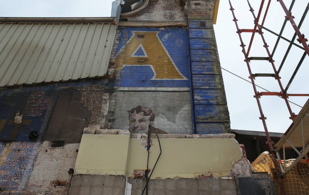 TASTY DISCOVERY: Part of the old advertising sign revealed after the demolition of the neighbouring building along Hunter Street in Newcastle West. Picture: Simone De Peak