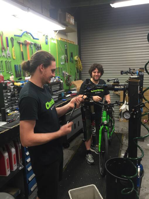 SUPPORT: Matt Miller (left) and John Ebeling at Cheeky Bikes, Warners Bay, repairing bicycles and giving moral support to our pedalling reporter. Picture: Scott Bevan  
