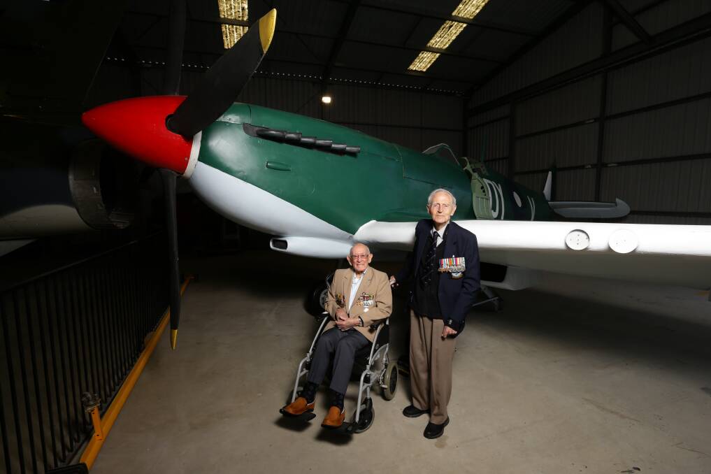 World War II pilots Charles "Clem" Jones and Sid Handsaker with a replica Spitfire at the Fighter World aviation heritage centre at Williamtown. Picture: Jonathan Carroll
