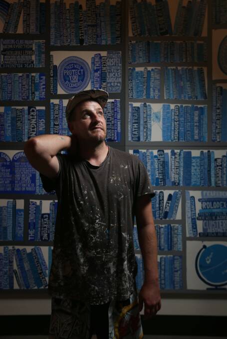 Artist Lucas Grogan in front of one of his "A Library" paintings at Maitland Regional Art Gallery. Picture: Simone De Peak 