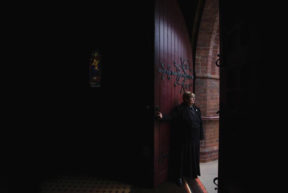 SHUT: The Very Reverend Katherine Bowyer, the Anglican Dean of Newcastle, closes the doors of Christ Church Cathedral. Picture: Marina Neil
