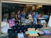 KINDNESS-FILLED GARAGE: Volunteers, including Matt Forde and family members, sort through donated items. Picture: Kylie Amos 