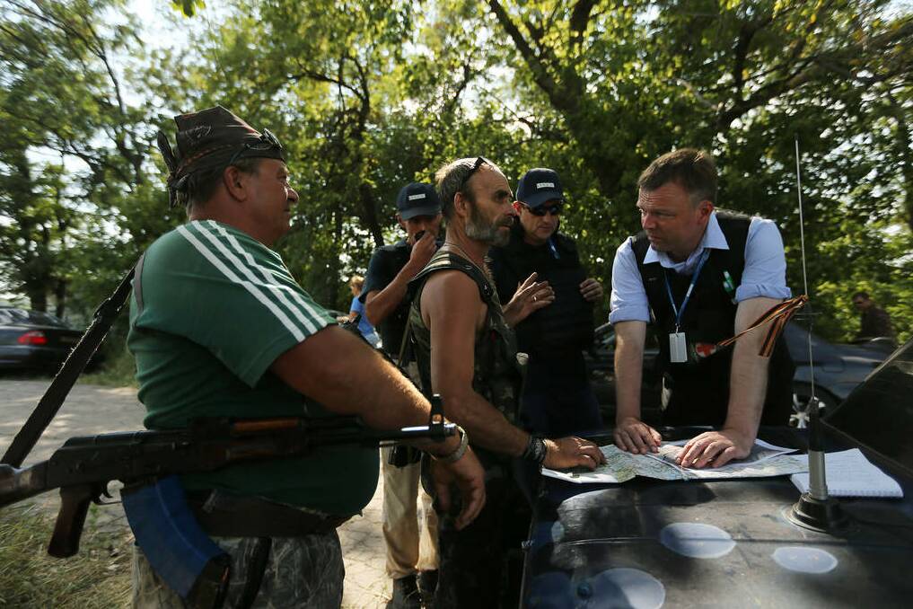 Pro Russian rebels negotiate with Deputy head of the OSCE mission Alexander Hug (right) a safe passage for the OSCE, Australian and Dutch police to and from the MH17 crash site near the chicken farm. Photo: Kate Geraghty