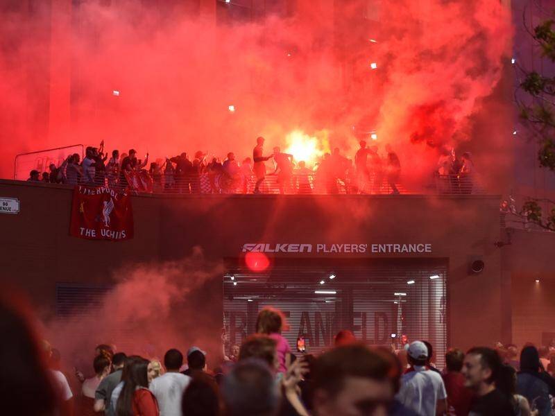 Ecstatic Liverpool fans celebrate outside Anfield stadium after the Reds' title victory on Thursday.
