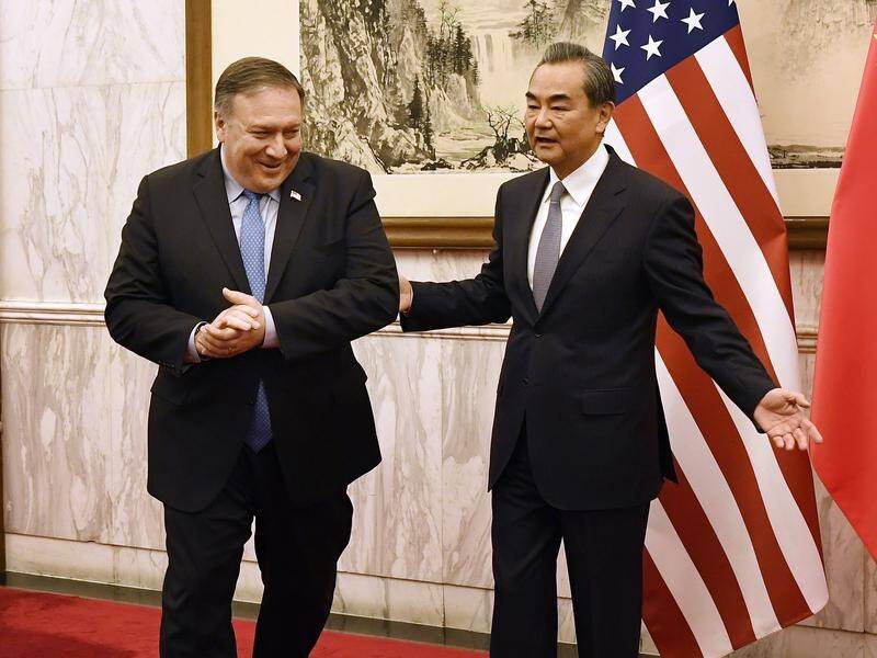 China's Wang Yi (R) has told Mike Pompeo the United States must show restraint on trade and Iran.
