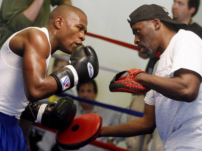 Roger Mayweather (r) works with his nephew and undefeated champion Floyd Mayweather.