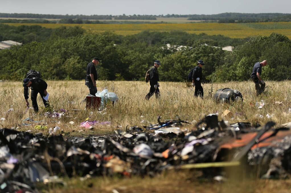 Australian Federal Police and their dutch counterparts searching at the MH17 crash site for human remains in order to bring them home. Photo: Kate Geraghty