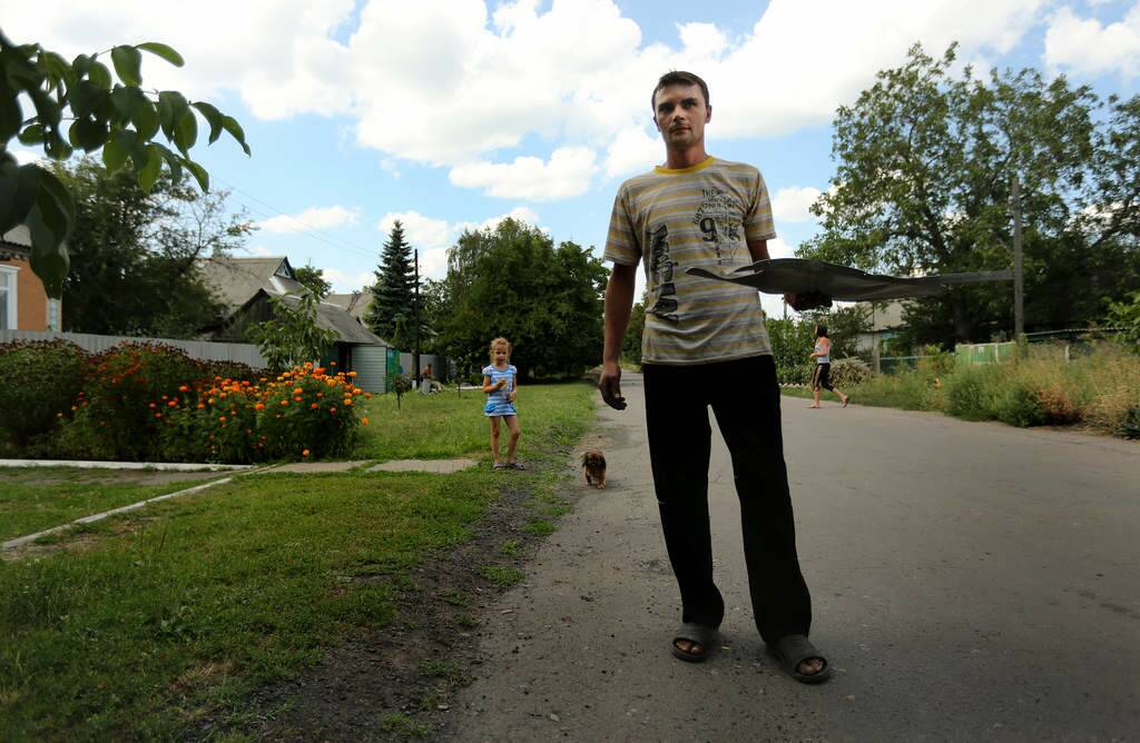Alexey Vladimirovich 27 brings a piece of MH17 flight debris and a silver necklace to the OSCE team in the Rassypnoe town in the self proclaimed Donetsk People's Republic, Ukraine. The OSCE, Australian Federal Police and their Dutch and Malaysian counterparts were in Rassypnoe to take possession of any debris from the MH17 plane crash on their last day of the international search. Photo: Kate Geraghty