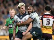 Cameron Munster (l) of the Storm celebrates scoring a try in his side's huge win over Brisbane. (Darren England/AAP PHOTOS)