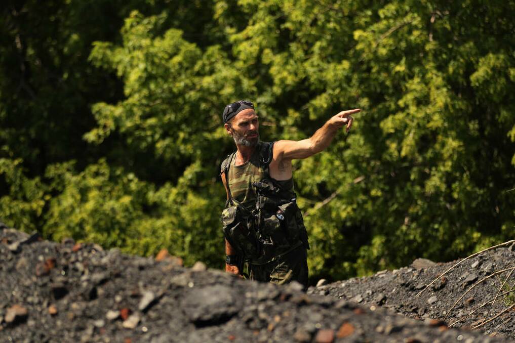 Pro Russian rebel Yuri looks near a slag heap where the International MH17 recovery team search for human remains of passengers from the MH17 crash, on the outskirts of Rassypnoe village. Photo: Kate Geraghty