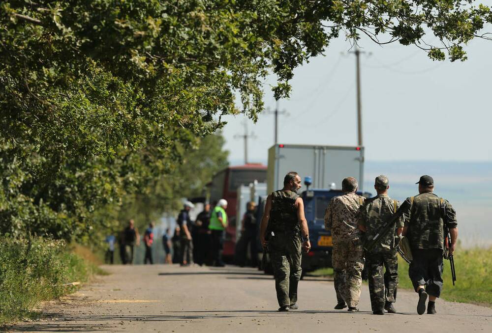 Pro Russian rebels who provide an escort in and around the MH17 crash site walk down the road towards the convoy of OSCE, AFP and their Dutch counterparts on the outskirts of Rassypnoye, where the Australian and Dutch experts will search for human remains and personal belongings of the passengers who died in the MH17 crash. Rassypnoye. Photo: Kate Geraghty