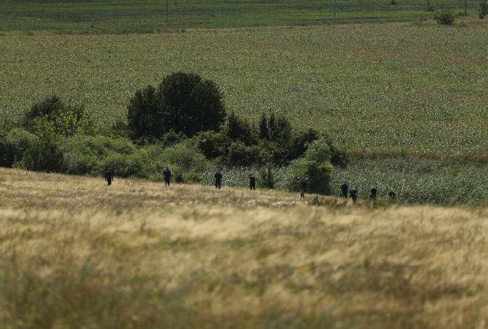 Australian Federal Police and their dutch counterparts searching at the MH17 crash site for human remains in order to bring them home. Photo: Kate Geraghty