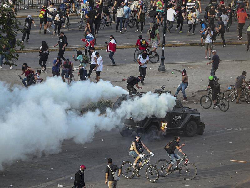 Demonstrators take on an armoured police vehicle during an anti-government march in Santiago, Chile.
