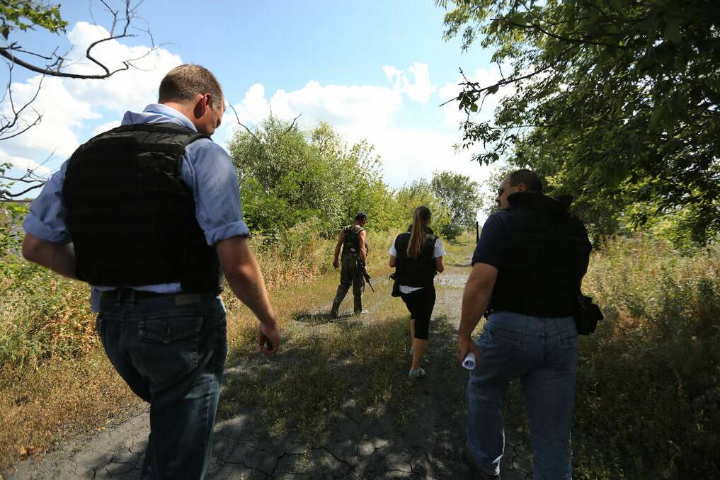 Deputy head of the OSCE mission Alexander Hug (left) with other OSCE members are escorted to a slag heap where the international MH17 recovery team will search for human remains of passengers from the MH17 crash, on the outskirts of Rassypnoe village. Photo: Kate Geraghty