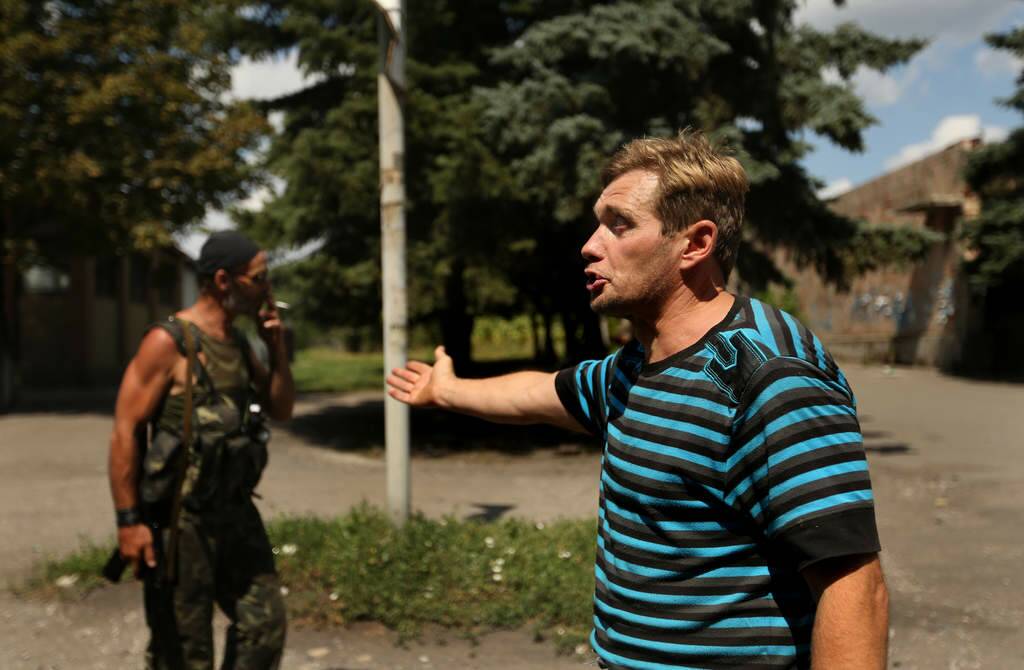 Sergey Vladimirovich 44 (right) points to Yuri (right) a Pro Russian rebel as he becomes outspoken about the war in Rassypnoe, also known as the cockpit village, where the MH17 cockpit landed in the crash. The town has been under heavy fire for the past week. Photo: Kate Geraghty