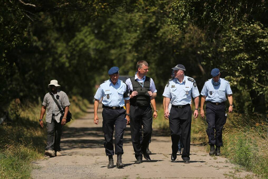 Australian Federal Police officer Brian McDonald (2nd from right) talks with his dutch counterpart Deputy head of the OSCE mission Alexander Hug (3rd from right) before the team starts searching at the MH17 crash site for human remains in order to bring them home. Photo: kate geraghty