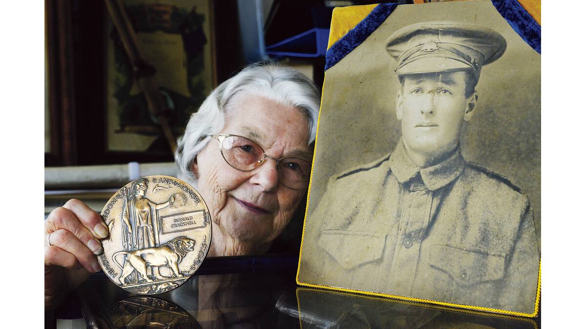 WE WILL REMEMBER THEM: Adele Cockburn with Private Donald Cracknell’s portrait and the bronze medallion.   