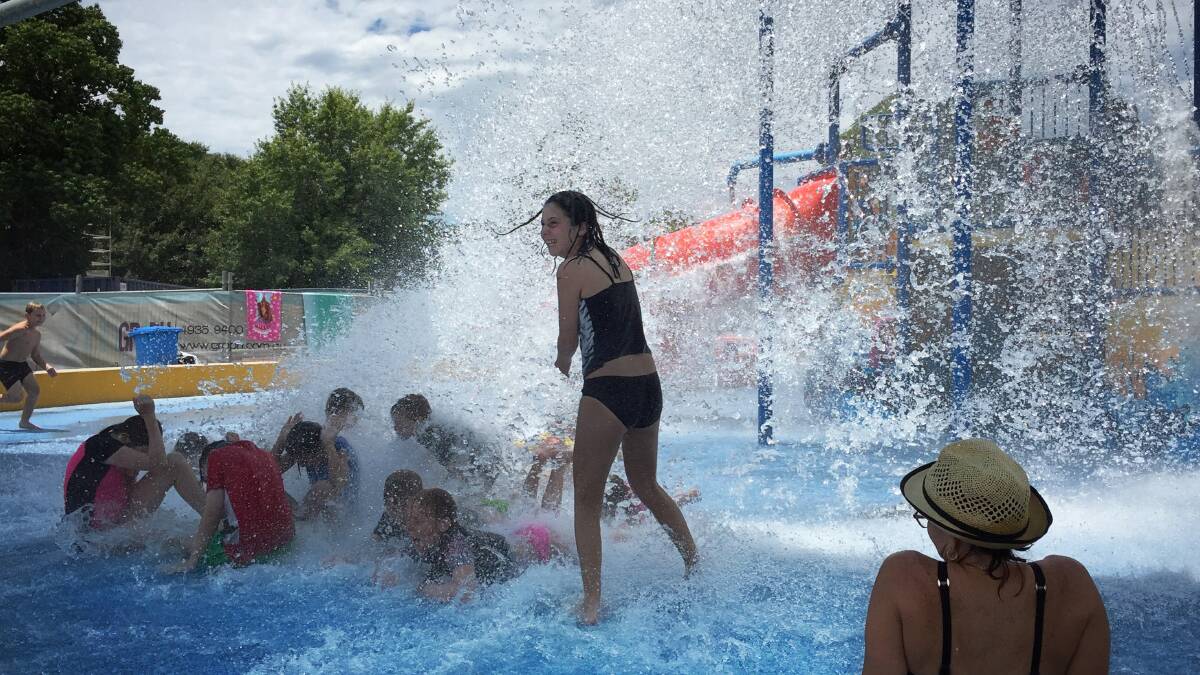 Splashing around: Children playing as a bucket of water falls at Maitland Pool. Picture: Simone De Peak