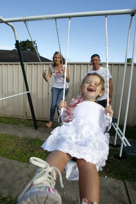  Three year old Mollyjane Boyson of New Lambton has a rare condition and was not expected to live much beyond birth. She has survived longer than anyone else in the world with her condition. Pictured on the back yard swing with her mother Jessica and father Daniel at their New Lambton home.  Picture MAX MASON-HUBERS 