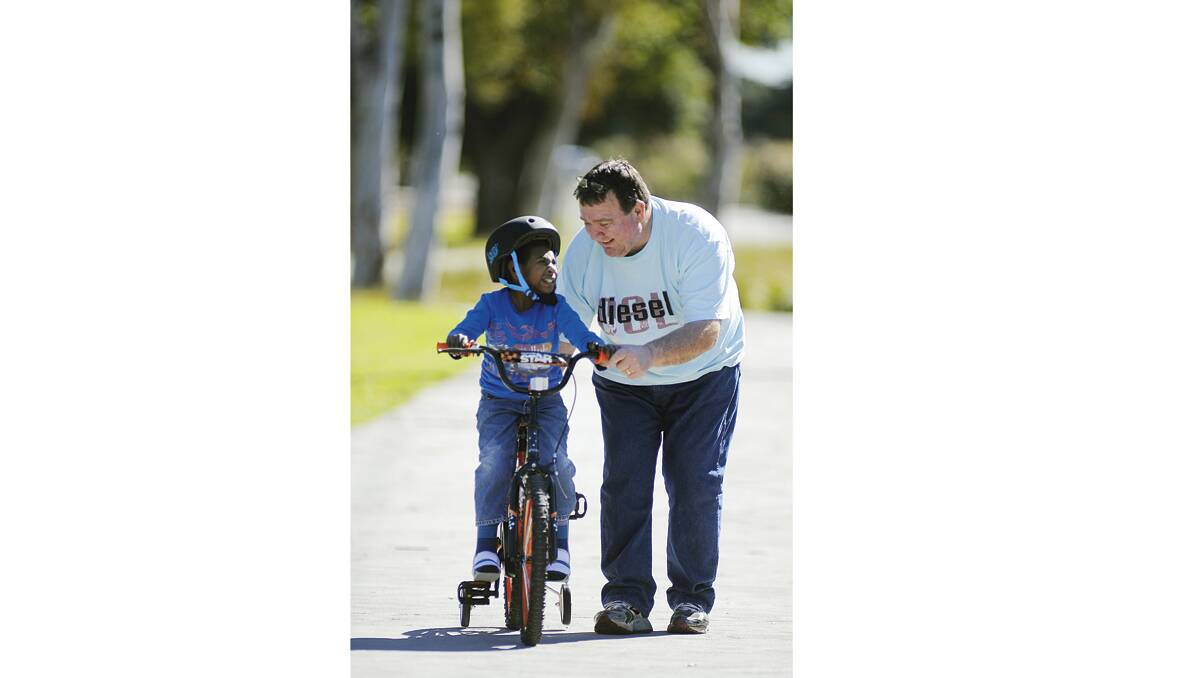 TRANSFORMED: Nurak Charley, or Charlie as his better known, gets a lesson on his new bike from East Maitland Rotarian Brian Coffey.
