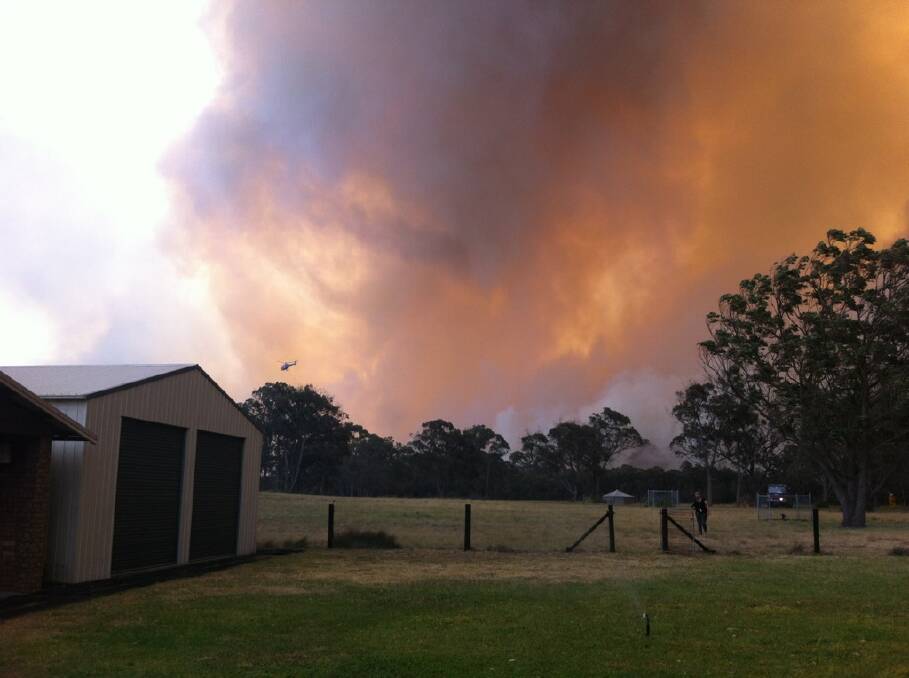 OUT OF CONTROL: The sky has turned to smoke in Heatherbrae as residents are told to evacuate the area - these images are looking north on Cabbage Tree Road. PICTURES: Marina Neil and Belinda -Jane Davis.