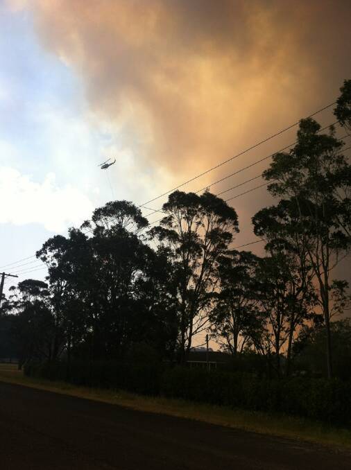 OUT OF CONTROL: The sky has turned to smoke in Heatherbrae as residents are told to evacuate the area - these images are looking north on Cabbage Tree Road. PICTURES: Marina Neil and Belinda -Jane Davis.